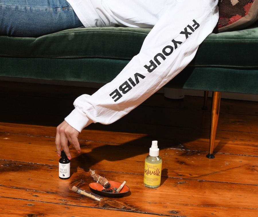 woman reaching for OG-tonic cbd with pre-roll and room-spray on the floor