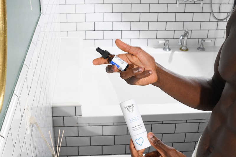 man holding chill-TONIC cbd in bathroom